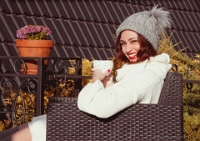 beautiful young woman drinking hot drink while taking sun tanning in winter time outside  (6)